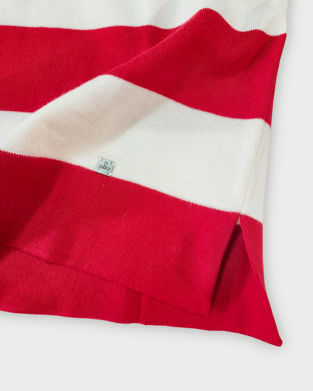 Dettaglio del fondo e del logo Edua della polo donna a righe rosse e bianche in maglia di cotone
