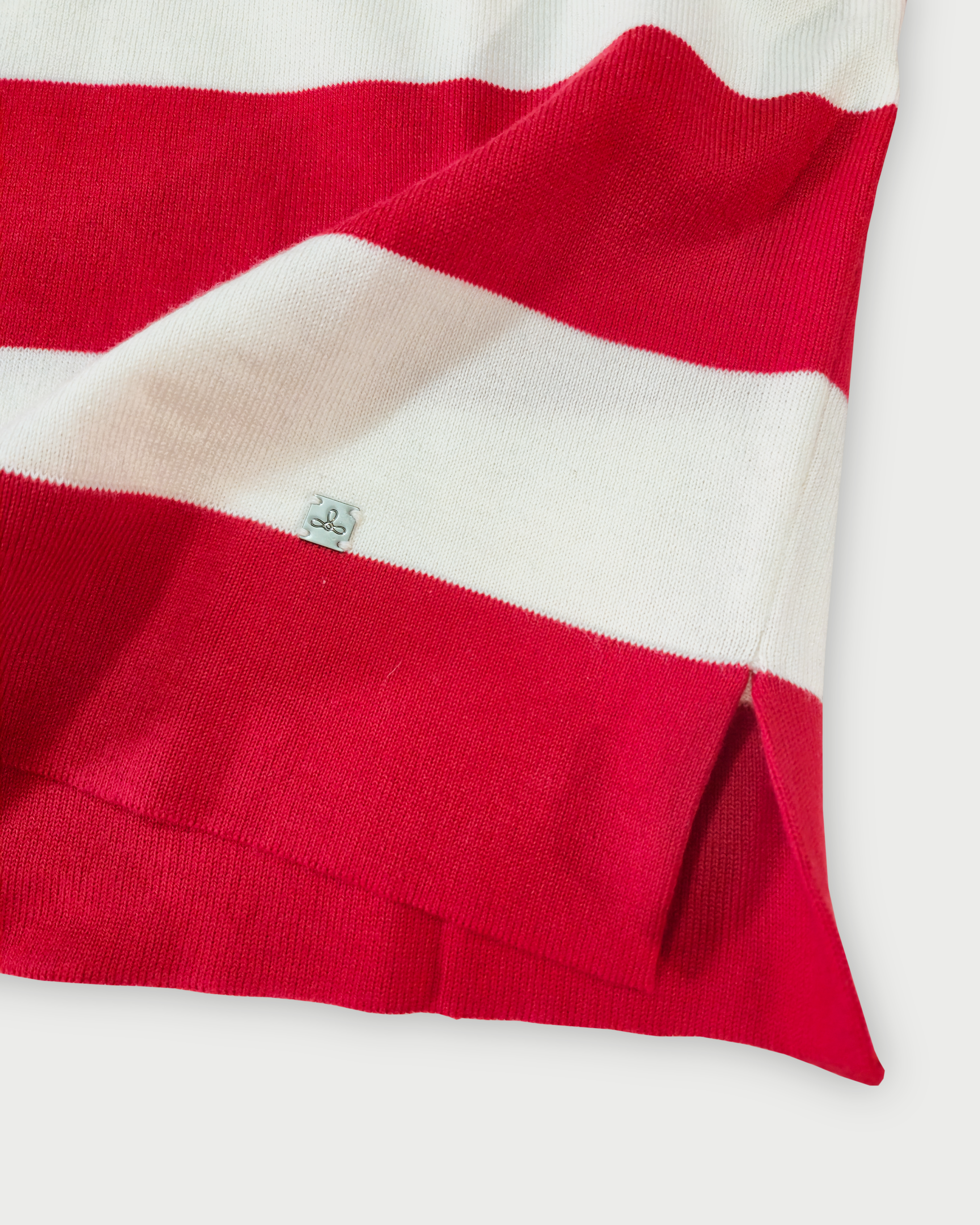 Dettaglio del fondo e del logo Edua della polo donna a righe rosse e bianche in maglia di cotone