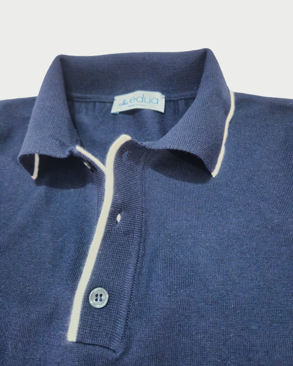 dettagli colletto Polo uomo in maglia di cotone blu su sfondo bianco