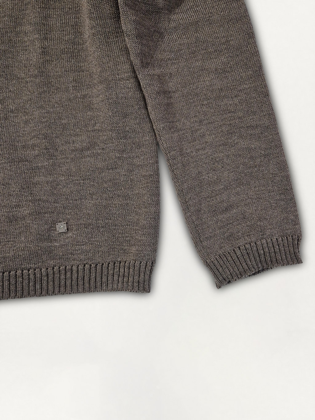 Dettaglio della manica e del logo Edua del maglione donna modello scatolina a collo alto in lana merino colore marrone