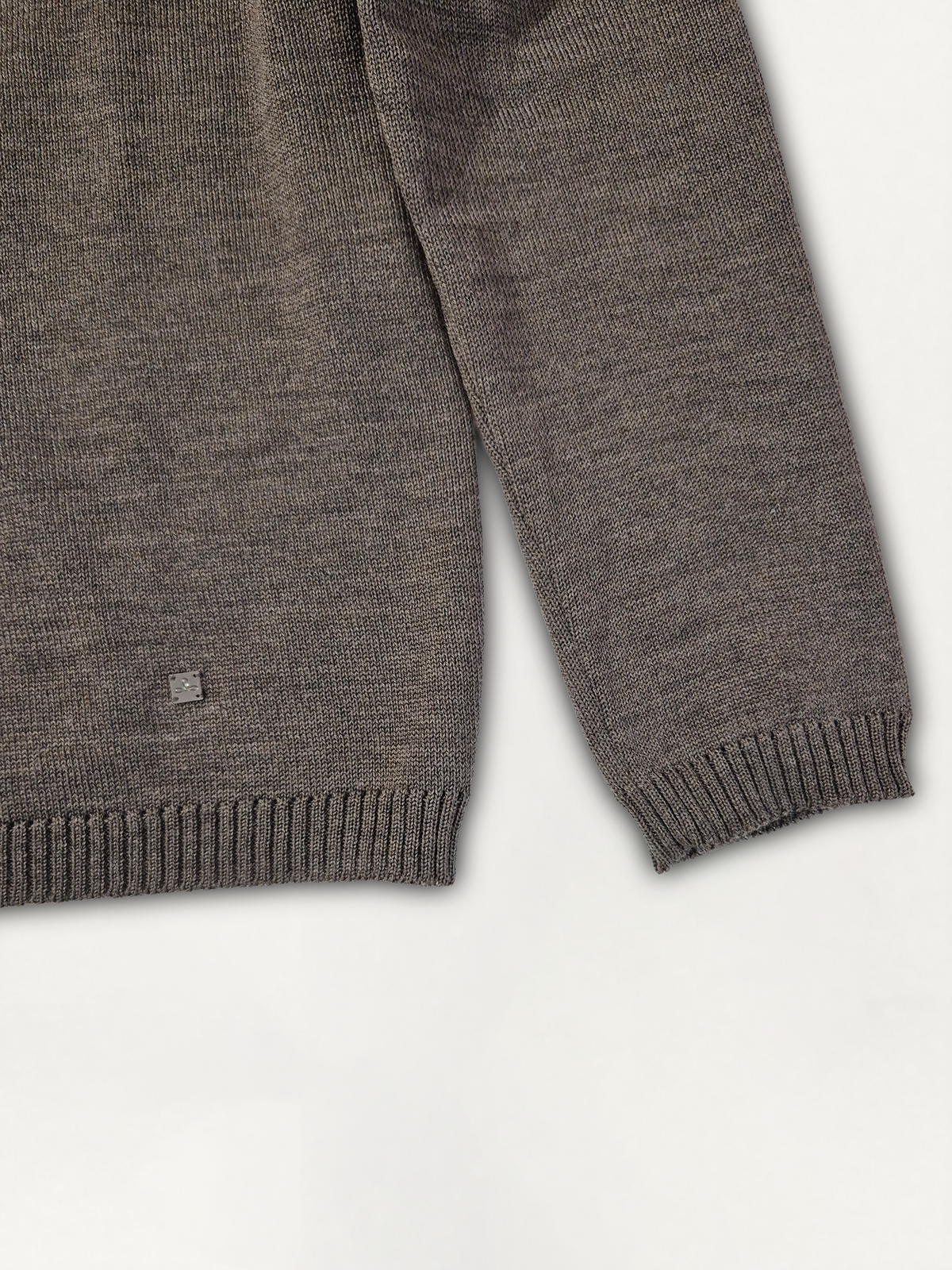 Dettaglio della manica e del logo Edua del maglione donna modello scatolina a collo alto in lana merino colore marrone