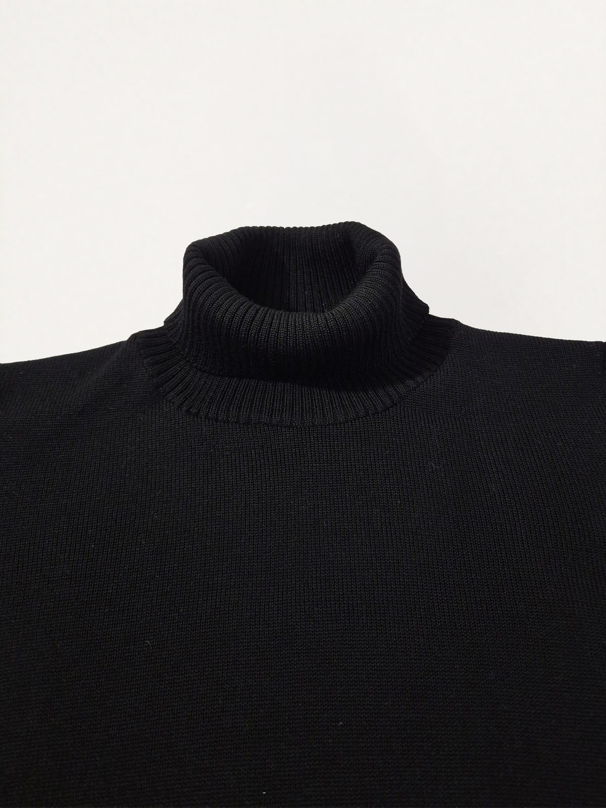 Dettaglio del collo del maglione donna modello scatolina a collo alto in lana merino colore nero