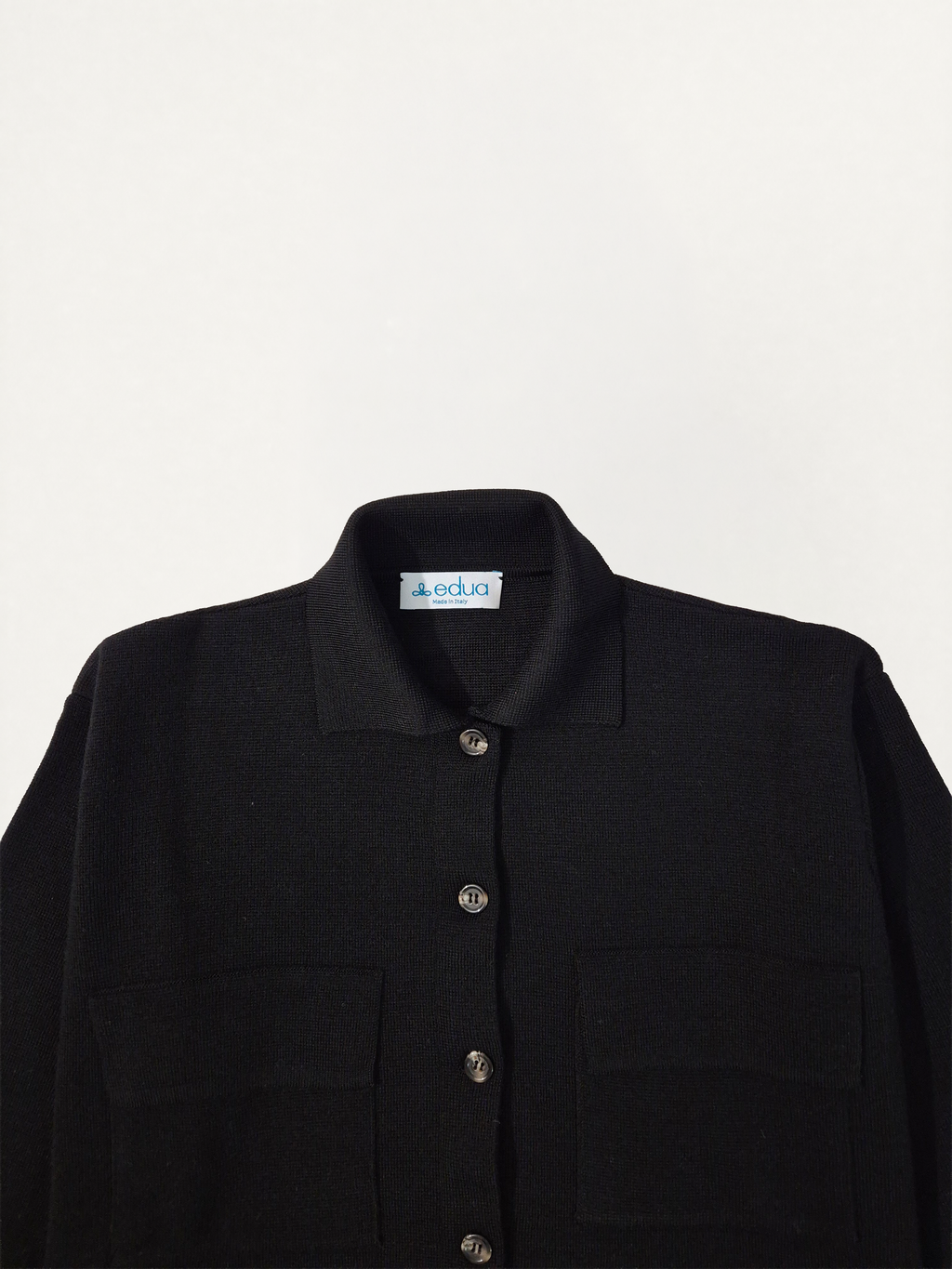 Dettaglio del collo della giacca in maglia donna in lana merino colore nero