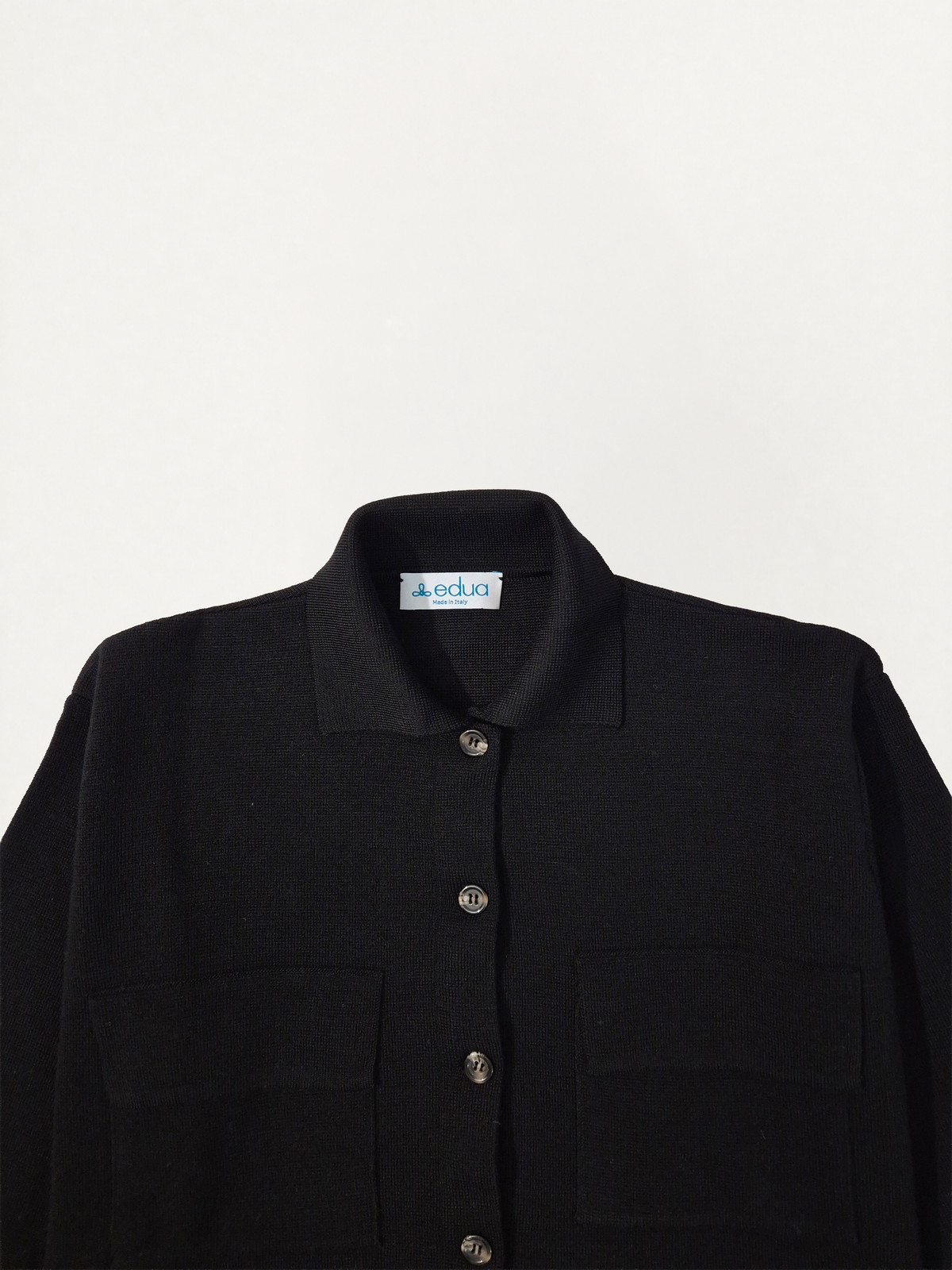 Dettaglio del collo della giacca in maglia donna in lana merino colore nero