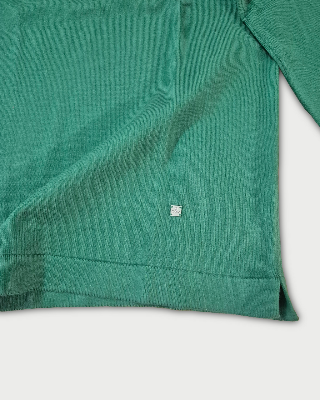Dettaglio fondo e logo Edua polo maniche lunghe uomo in maglia di cotone verde su sfondo bianco