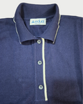 Dettaglio del colletto con bordini bianchi della polo donna over in maglia di cotone blu su sfondo bianco
