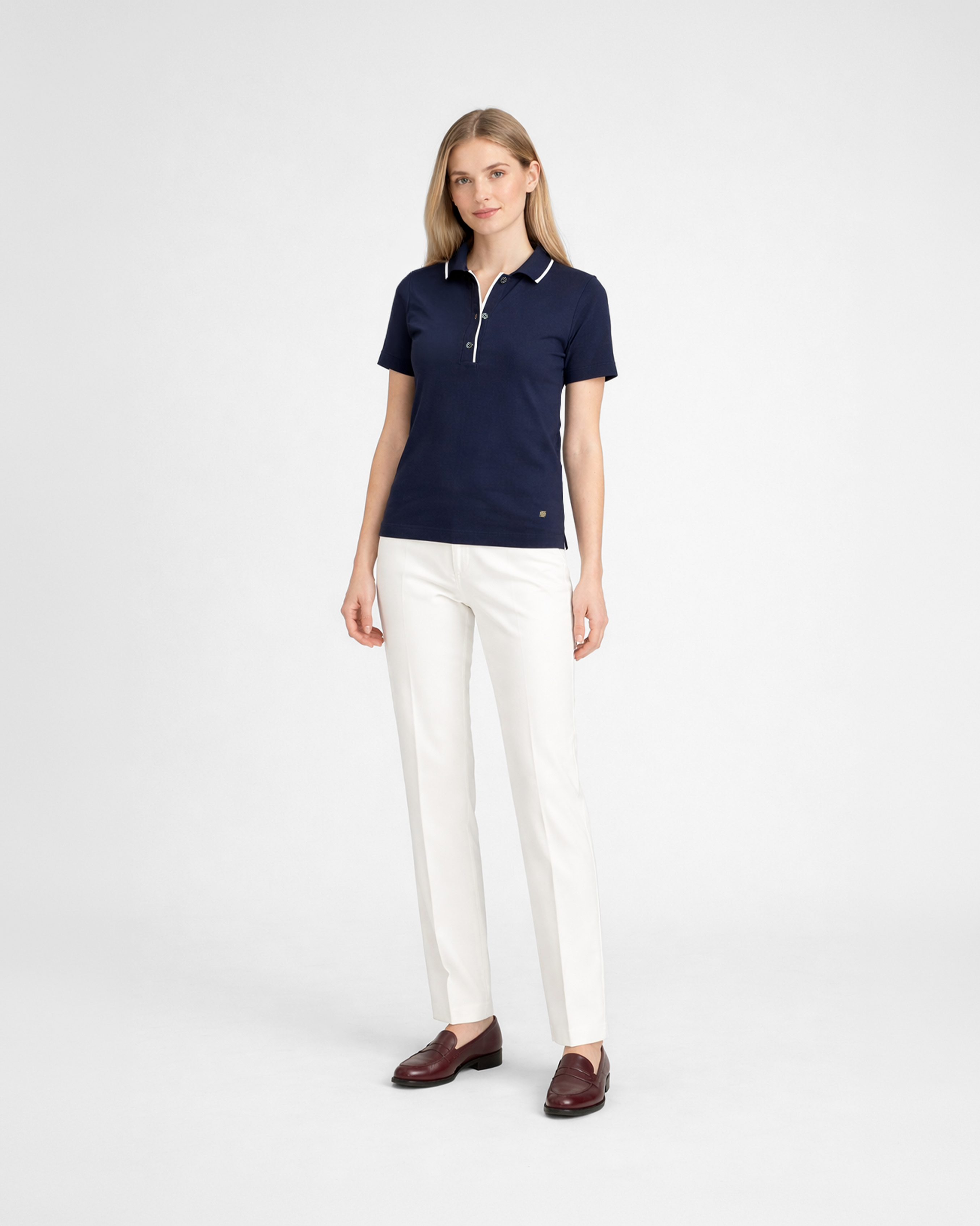 Polo donna in maglia di cotone blu con colletto e bordi bianchi indossata su sfondo bianco