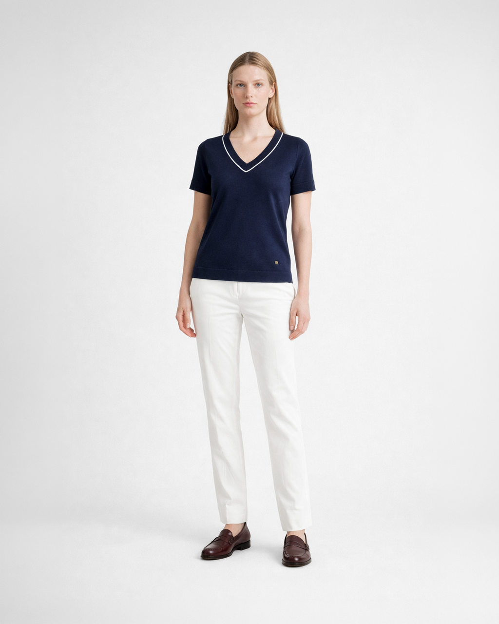 Maglia donna in maglia di cotone blu con scollo a V e profilo blu indossata su sfondo bianco